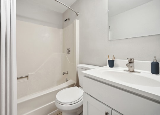 Model Bathroom with White Cabinets, Tile Flooring and Shower/Tub at Middlesex Crossing Apartments in Billerica, MA.