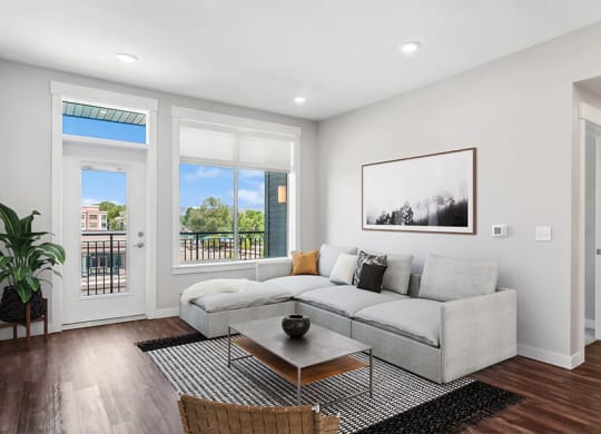 Model Living Room with Wood-Style Flooring and Patio Accessibility at Seven Skies Apartments located in Sandy, UT.