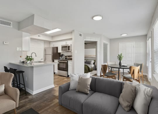 the living room and kitchen of an apartment with a couch and a table