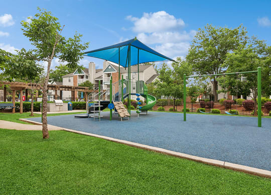 Community Playground with a Slide, Blue Canopy and Swing Set at Park 2300 Apartments in Charlotte, NC.