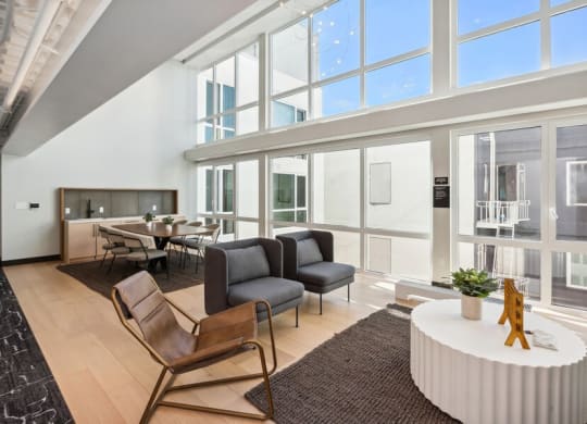 Indoor lounge and dining area with large sun windows at TL Residences