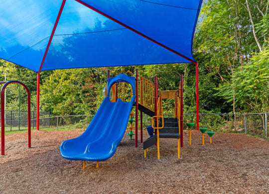 Community Playground with Slide and Blue Canopy at Heights at Marlborough Apartments located in Marlborough, MA.