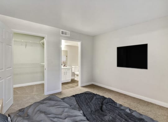 Model bedroom with a bed and a television on the wall