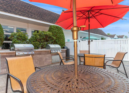 Outdoor BBQ Area with Furniture at Village at Marshfield Apartments located in Marshfield, MA.