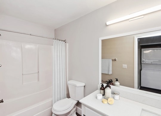 Model Bathroom with White Cabinets, Wood-Style Flooring and Shower/Tub at Vue at Baymeadows Apartments in Jacksonville, FL.