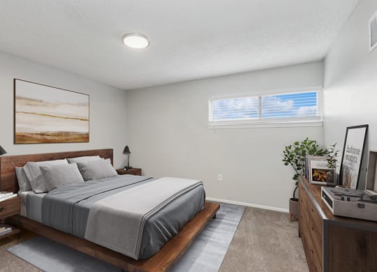 Model Bedroom with Carpet and Window View at Parc at Creekside Apartments in Kansas City, MO.