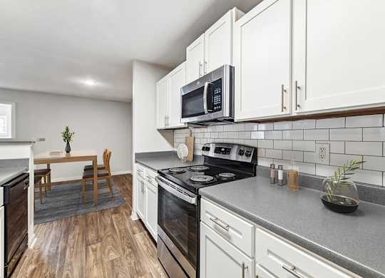 Model Kitchen with White Cabinets and Wood-Style Flooring at Lake Cameron Apartments located in Apex, NC.