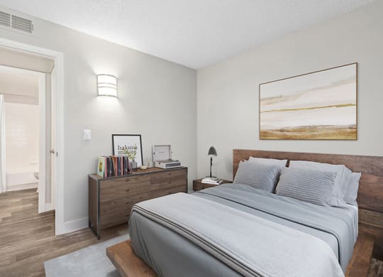 Model Bedroom with Wood-Style Flooring and attached Bathroom at Peaks on 4th Apartments in Avondale, AZ.