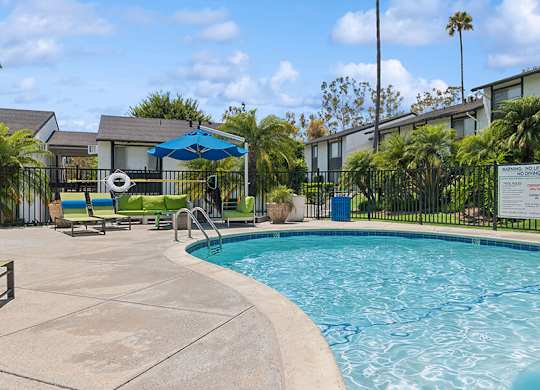 Community Swimming Pool with Pool Furniture at Fullerton Hills Apartments located in Fullerton, CA.