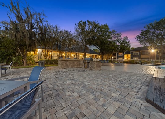 Outdoor BBQ Area with Furniture and Pool View at Walden Lake Apartments in Plant City, FL.