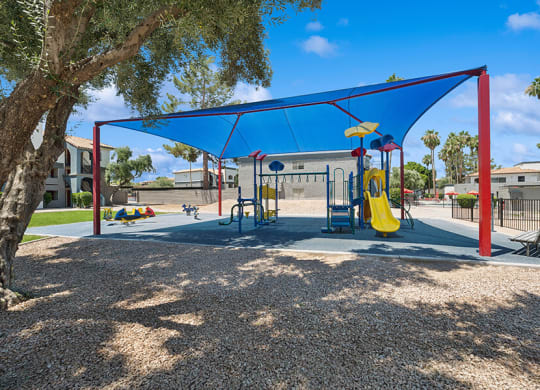 Community Playground with a Slide and Blue Canopy at Country Club Verandas Apartments located in Mesa, AZ.
