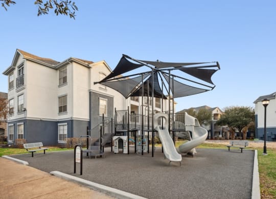 Community playground with sun cover at Park West Apartments in Houston, Texas