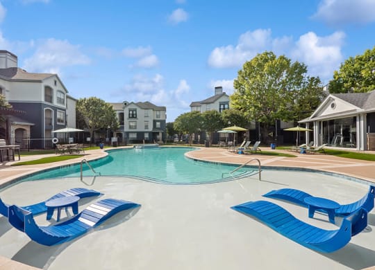 Community Swimming Pool with Pool Furniture at Park West Apartments located in Houston, TX.