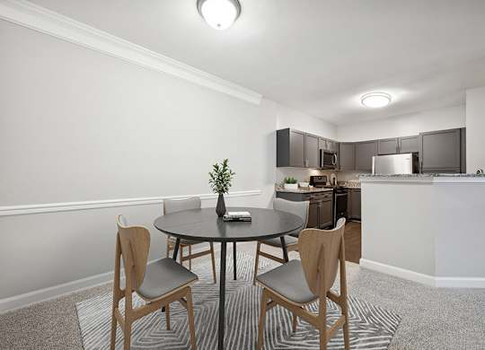 Model Dining Room with Carpet and View of Kitchen at Dulles Green Apartments located in Herndon, VA.