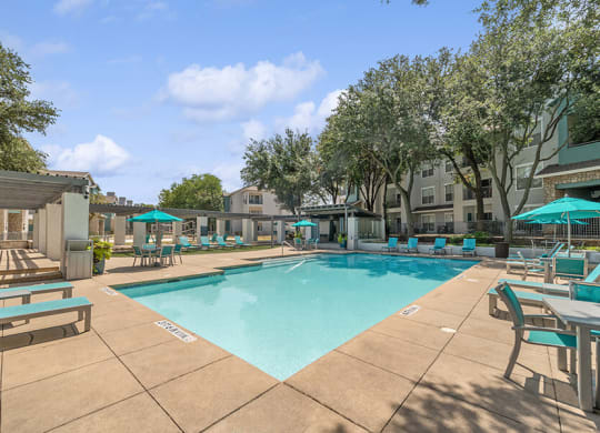 Community Swimming Pool with Pool Furniture at Essence Apartments in Dallas, TX.
