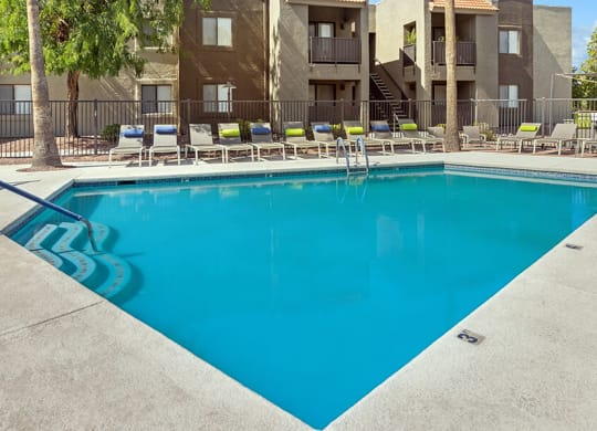 Community Swimming Pool with Pool Furniture at Saddle Ridge Apartments in Tucson, AZ.