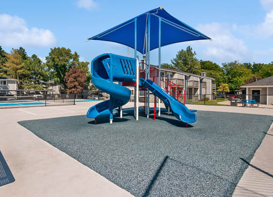 Community Playground with two Slides and Blue Canopy at Overlook Apartments located in Salt Lake City, UT.