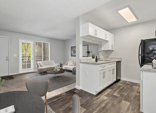Model Kitchen with White Cabinets and Wood-Style Flooring with View of Dining/Living Room Area at Stillwater Apartments in Glendale, AZ.