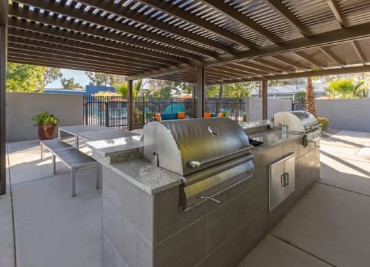 An outdoor kitchen with a grill and a pergola  at Lakeside Casitas in Tucson, AZ