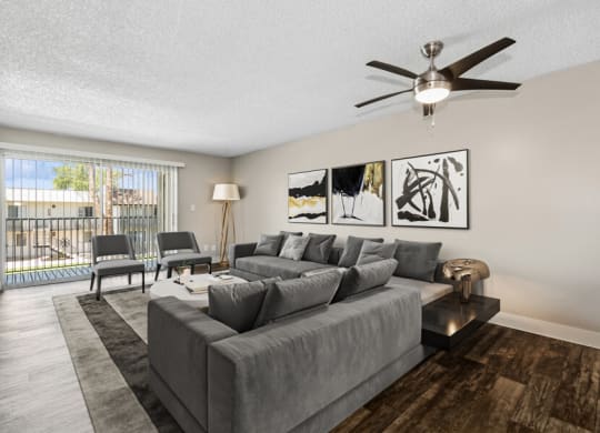 a living room with a large couch and a ceiling fan at Villages at Metro Center, Phoenix