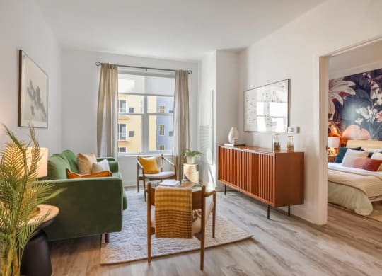 Model living room with a lot of pillows and chairs and a window