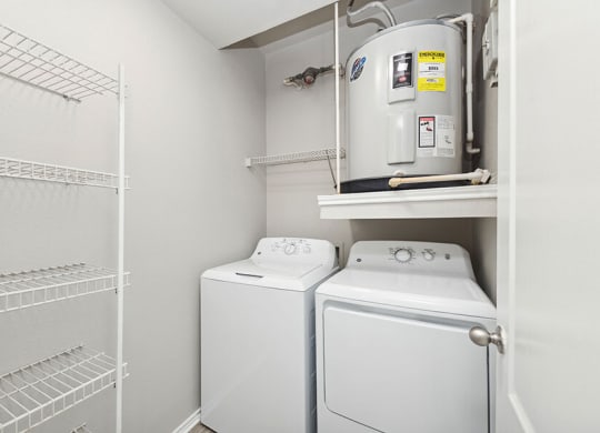 Model Laundry Room with Wood-Style Flooring, Water Heater & Storage Shelves at Allure North Dallas Apartments located in Dallas, TX.
