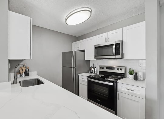 Model Kitchen with White Cabinets and White Marble Countertops at Fountains Lee Vista Apartments in Orlando, FL.