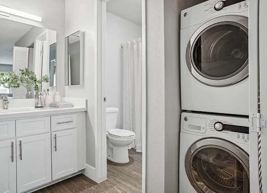 Model Bathroom with White Cabinets and Wood-Style Flooring at Cove La Mesa Apartments located in La Mesa, CA.