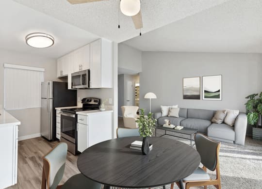 Model Dining Room and Kitchen with White Cabinets and Wood-Style Flooring at Bridges on Sunset Apartments in Suisun City, CA.