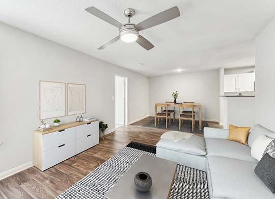 Model Living Room with Wood-Style Flooring and View of Dining Room at Lake Cameron Apartments located in Apex, NC.