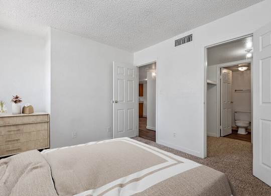 Model Bedroom with Carpet and attached Bathroom at District at Fiesta Park Apartments located in Mesa, AZ.
