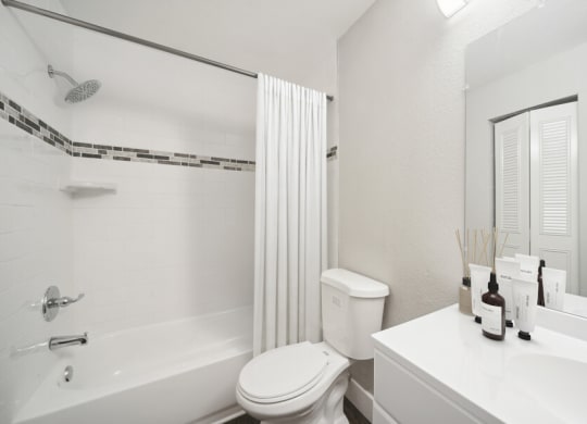 a bathroom with a white toilet sitting next to a bath tub