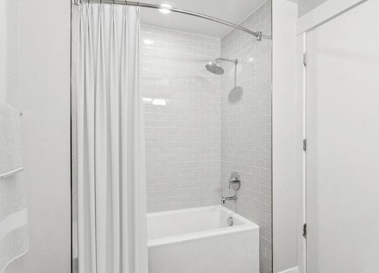 Model Bathroom with Wood-Style Flooring and Shower/Tub at Seven Skies Apartments located in Sandy, UT.