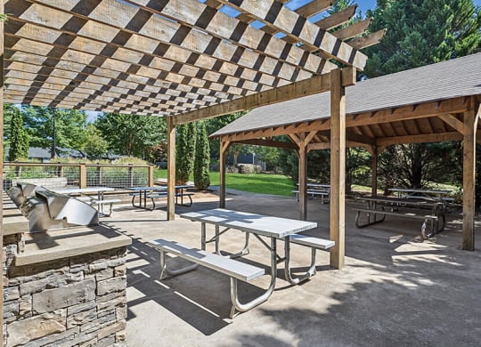 Outdoor BBQ Area with Canopy and Picnic Tables at Lakeside Retreat Apartments located in Peachtree Corners, GA.