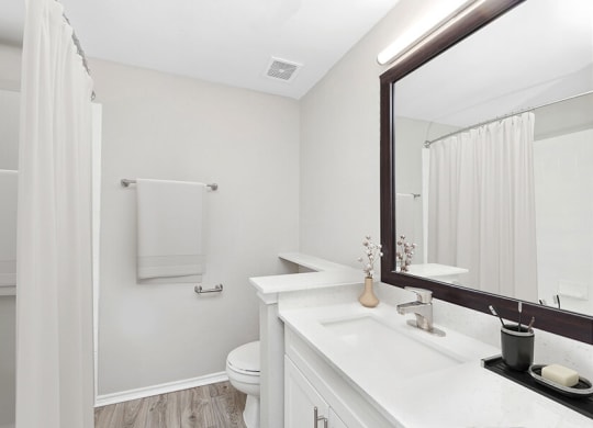 Model Bathroom with Wood-Style Flooring, White Cabinets & Shower/Tub at Allure North Dallas Apartments located in Dallas, TX.