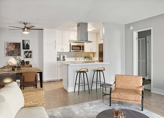 Model Living Room with Wood-Style Flooring and View of Kitchen at Cove La Mesa Apartments located in La Mesa, CA.
