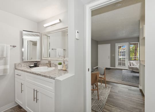 Model Bathroom with White Cabinets and Wood-Style Flooring at Stillwater Apartments in Glendale, AZ.