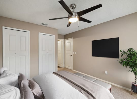 Model bedroom with a bed and a ceiling fan at Vue at Baymeadows Apartments in Jacksonville, Florida