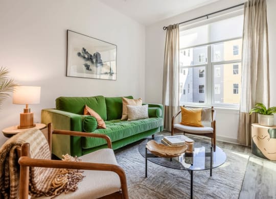 Model living room with a green couch and a window