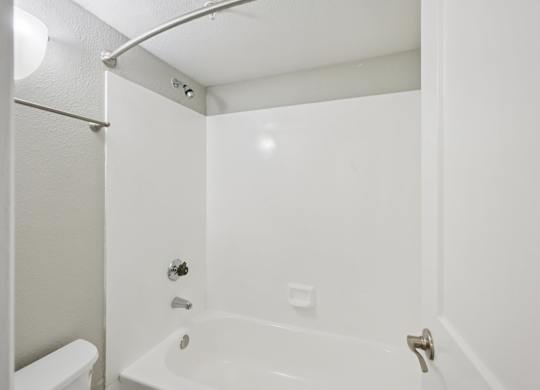 Model white bathroom with a tub, toilet and sink.