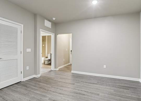 Model living room with a wood-stlye floor and white walls.