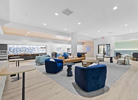 A spacious waiting area with blue chairs and a wooden floor.
