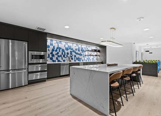 A modern kitchen with a marble island and stainless steel appliances.