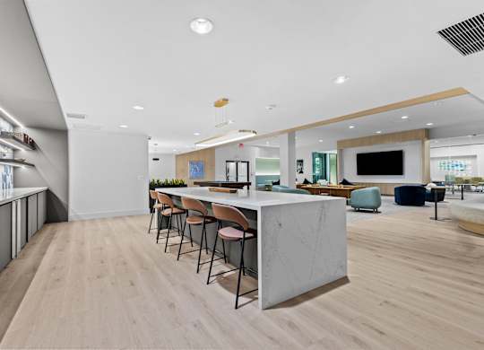 A modern kitchen with a long table and chairs.