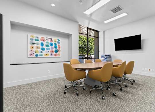 A conference room with a large table and chairs.
