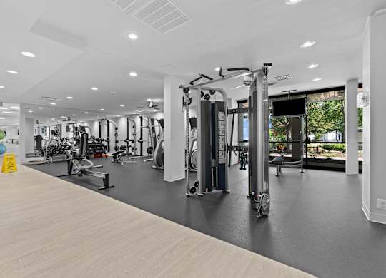 A gym with a variety of equipment including treadmills, weights, and exercise machines.