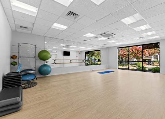 A spacious room with exercise equipment and a yoga mat.