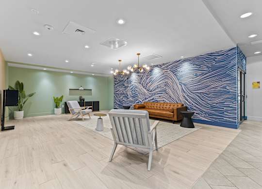A blue and white marbled wall in a room with a chair and a table.