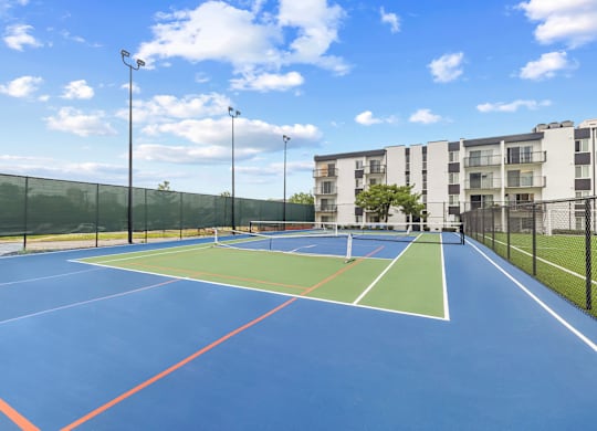 A tennis court with a blue surface and red lines.