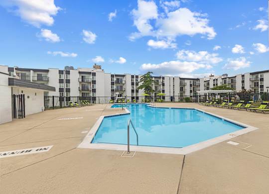 A large swimming pool in front of apartment buildings.